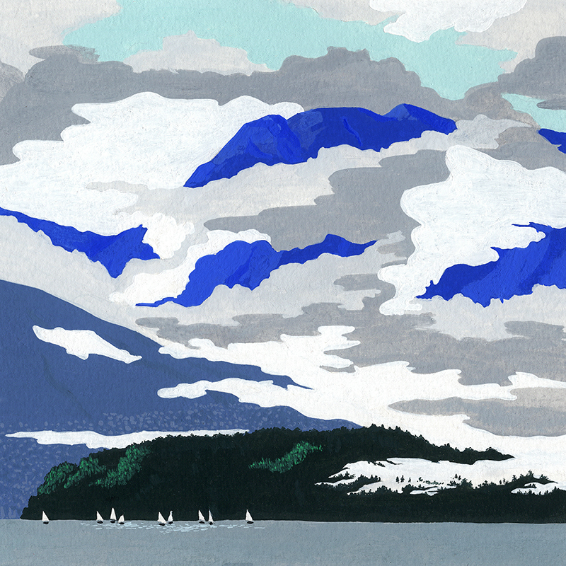 Clouds obscure blue mountainsides and settle into a forest at sea level where there are several sailboats