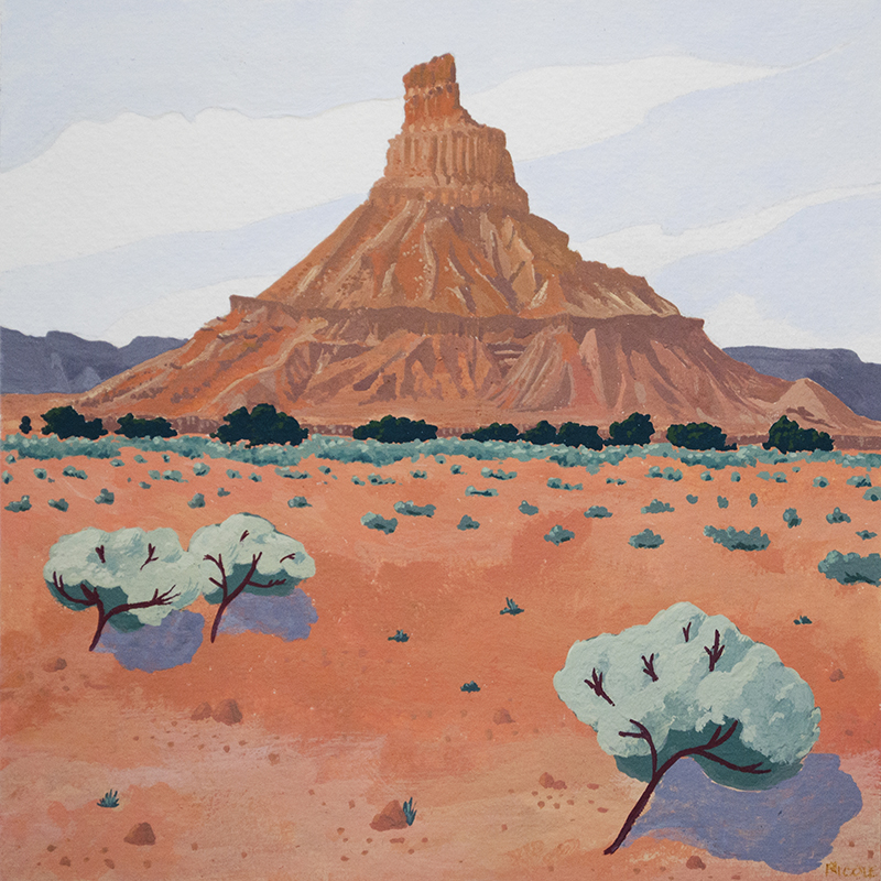 An orange geologic tower in front of a big blue sky. Various types of wild west vegetation scattered in the foreground